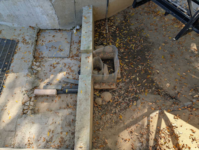 Reservoir dam wall with dirt and leaves